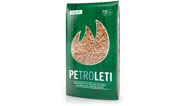 Na sliki je vreča lesenih peletov Petrol (Petroleti), pakirana v zeleni embalaži s prozornim delom, skozi katerega se vidijo peleti.