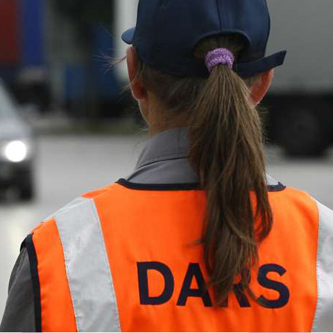 Zadnja stran osebe v odsevnem brezrokavniku z napisom DARS.