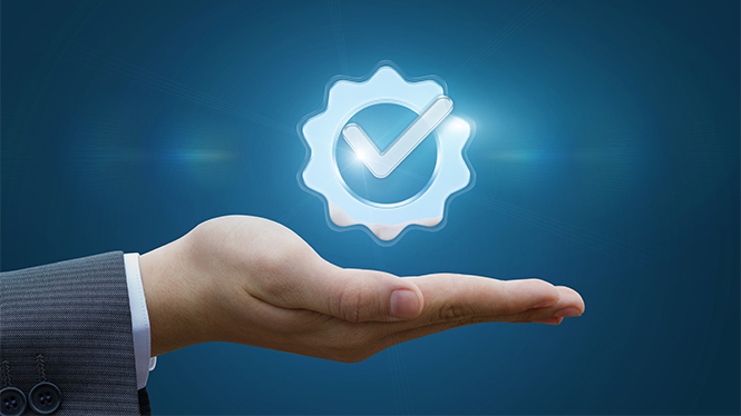 Na sliki je dlan osebe v poslovni obleki, nad katero lebdi moder svetleč simbol zobnika z vključenim kljukastim znakom, na temno modrem ozadju.