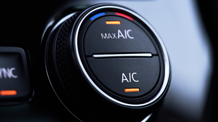 Na sliki je gumb za upravljanje avtomobilske klimatske naprave (A/C). Okoli gumba so barvne oznake za nastavitev temperature.