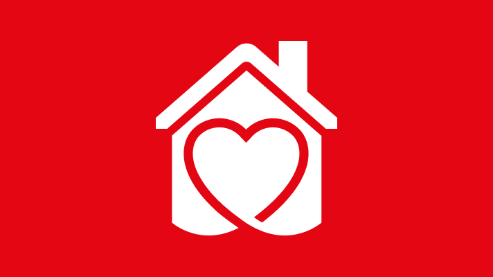 Na sliki je bela ikona hiše, ki ima v notranjosti oblikovan srček. Hiša je narisana s streho in dimnikom, srce pa zavzema večino notranjega prostora hiše. Ozadje je enotne rdeče barve.