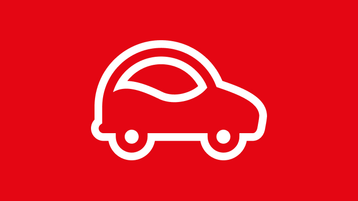 Na sliki je bela ikona avtomobila. Avto je prikazan od strani, z dvema kolesoma in zaobljeno obliko karoserije, zrisanimi okni in obrobo. Ozadje je enotne rdeče barve.