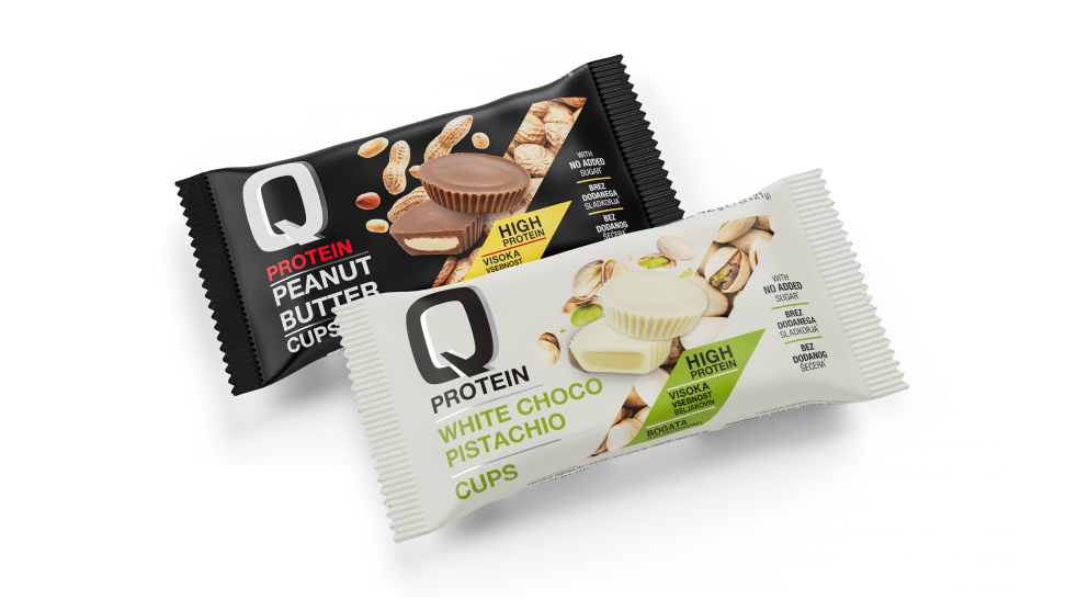 Na sliki z belim ozadjem sta prikazana oba Q protein cupsa v okusu arašid čokolada in bela čokolada pistacija.