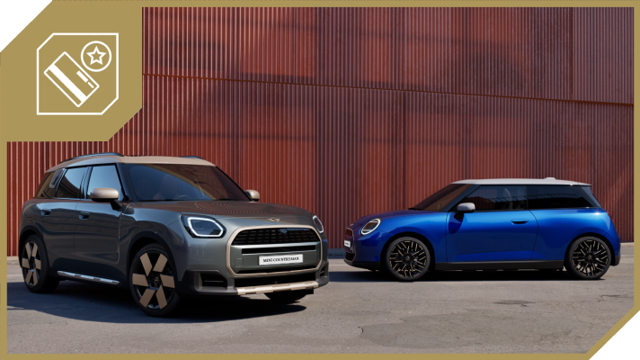 Na sliki sta dva avtomobila Mini, parkirana pred zgradbo z rdečo fasado. V ospredju je siv Mini Countryman, v ozadju pa modri Mini Cooper. V levem zgornjem kotu je prikazana ikona kartice z zvezdico. Vozili stojita na asfaltni površini pred stavbo s kovinsko oblogo.