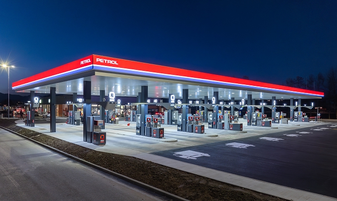 Sodobni Petrolov bencinski servis v večernem času z osvetljenim nadstreškom in več točilnimi mesti za gorivo. Servisna postaja je urejena in dobro osvetljena ter omogoča oskrbo različnih vozil.