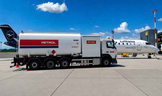 Petrolova cisterna za letalsko gorivo stoji ob letalu Lufthansa na letališki ploščadi.