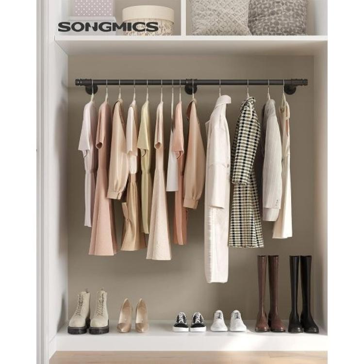 Songmics kovinska obešalna palica za oblačila nameščena v omari z obešenimi oblačili.