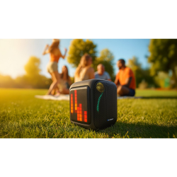 Prenosni zvočnik Blaunpunkt z RGB LED stranskim prikazom, postavljen na travi, primeren za uporabo na prostem.