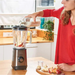 Priprava smoothieja z Black+Decker blenderjem, kjer se v stekleno posodo dodaja mleko k sadju za mešanje napitka