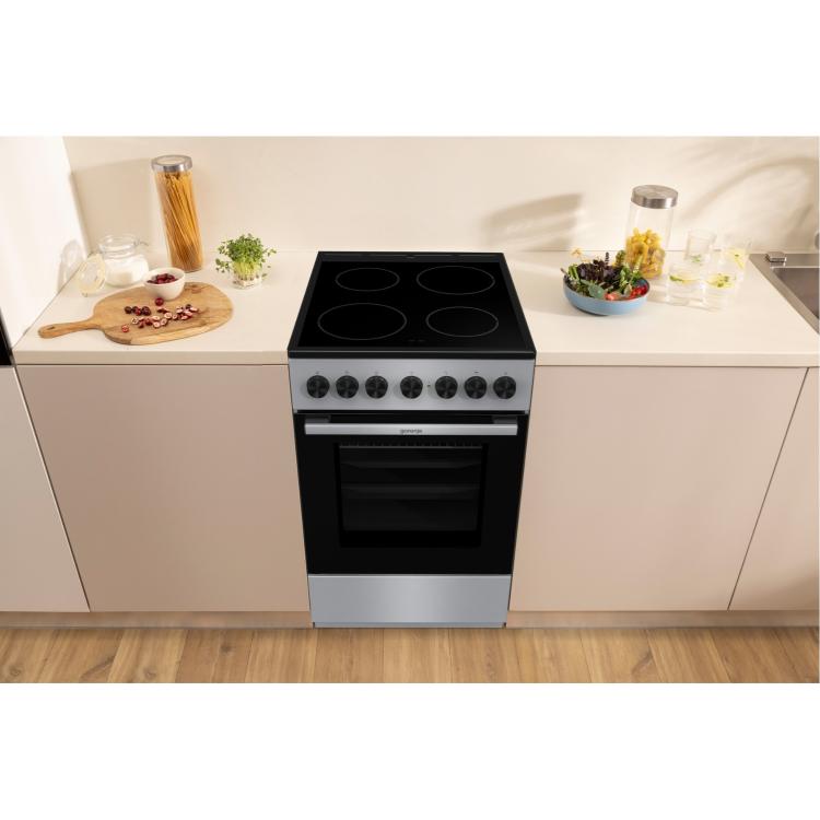 Električni štedilnik Gorenje GEC5B60SG, nameščen v sodobni kuhinji med kuhinjskimi elementi.