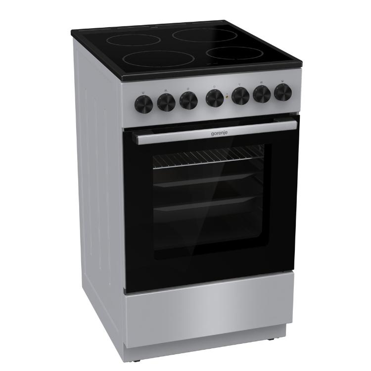 Električni štedilnik Gorenje GEC5B60SG, prikazan iz sprednje stranske perspektive s steklokeramično kuhalno ploščo in prostorno pečico.