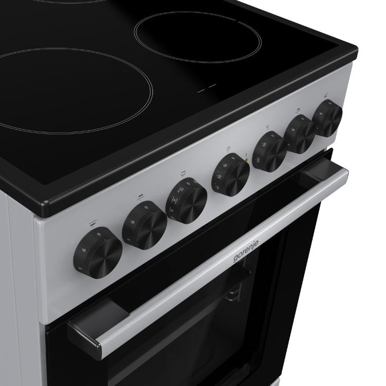 Upravljalna plošča in steklokeramična kuhalna plošča električnega štedilnika Gorenje GEC5B60SG s sedmimi vrtljivimi gumbi.