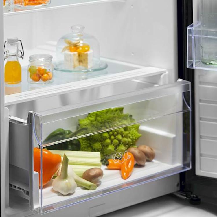 Predal za sadje in zelenjavo v hladilniku Electrolux z vidno svežo zelenjavo.