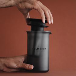 Goat Story Cold Brew, roka namešča pokrovček na vrč, mat črno ohišje in minimalističen dizajn.