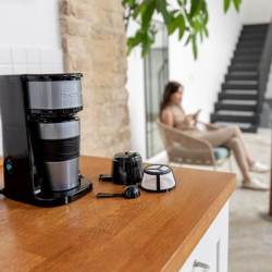 Cecotec aparat za filter kavo v črno-srebrni barvi, prikazan z odstranljivim filtrom in merilno žličko za kavo.