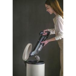 Baterijski sesalnik Hoover v uporabi, praznjenje posode za prah neposredno v koš.