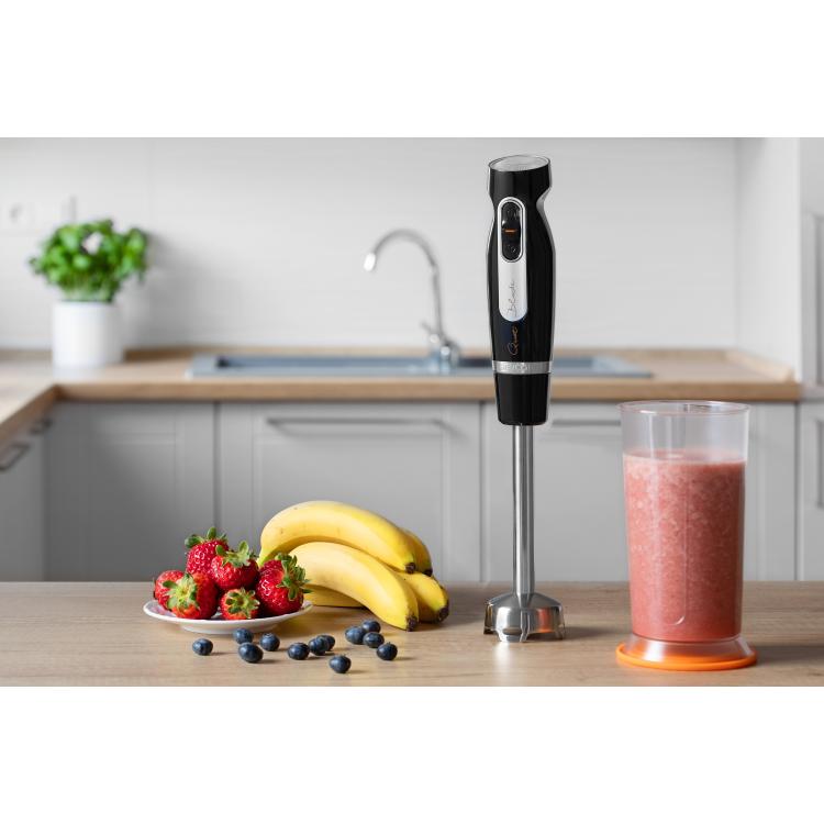 Palični mešalnik Sencor na kuhinjskem pultu z merilno posodo in svežim sadjem.