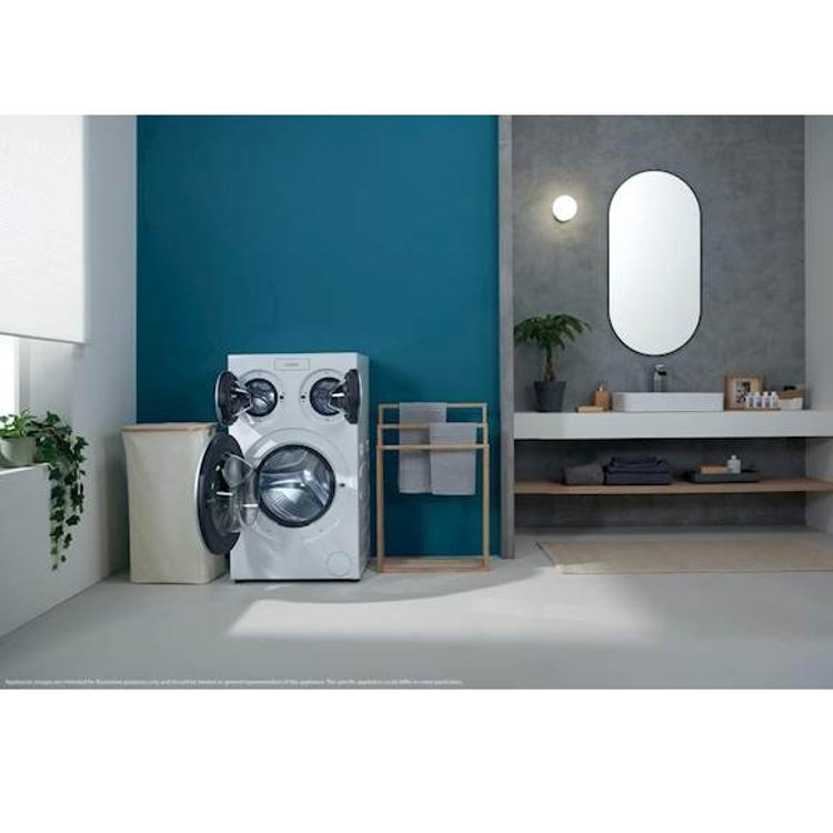 Pralni stroj Candy MQD 410CBL9‑S postavljen v sodobni kopalnici, prikaz uporabe v prostoru.
