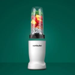 Nutribullet osebni blender z napolnjeno posodo (sadje, listnata zelenjava, led) na zeleni podlagi