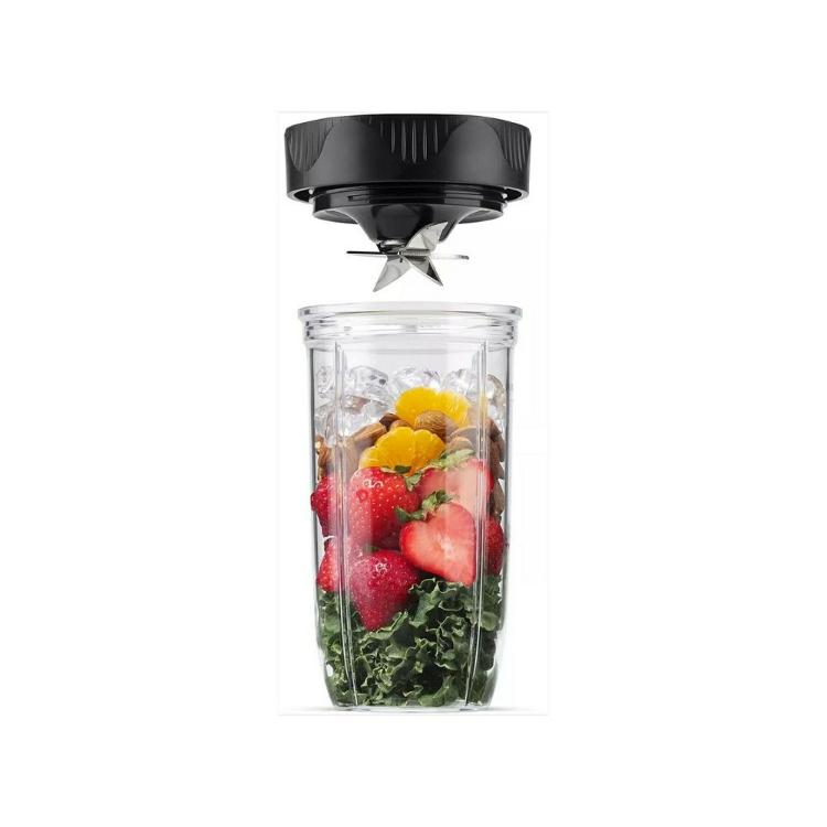 Detajl Nutribullet mešalne posode z rezilnim nastavkom in sestavinami (jagode, citrusi, oreški, ohrovt)