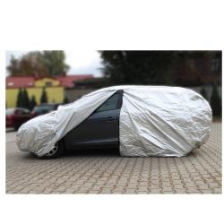 Siv avto delno odkrit; polovica vozila prekrita s prevleko, vidna vrata, okno in kolo.