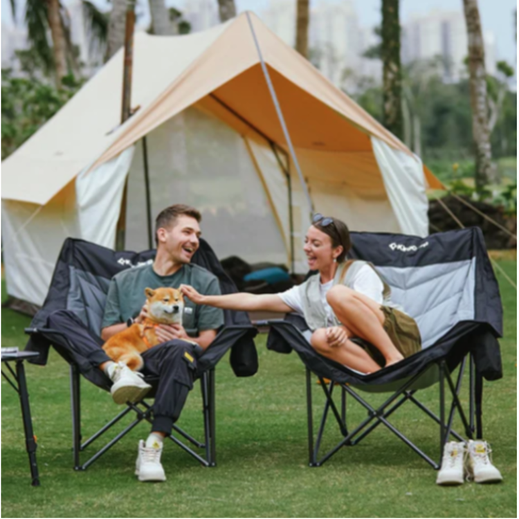 Dva zložljiva kamping stola KingCamp v uporabi na prostem pred šotorom.