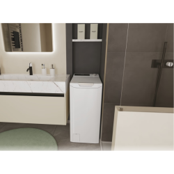 Pralni stroj z zgornjim polnjenjem postavljen v kopalnici ob umivalniku