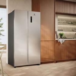 Srebrn ameriški hladilnik Electrolux, postavljen v sodobni kuhinji z lesenimi elementi.