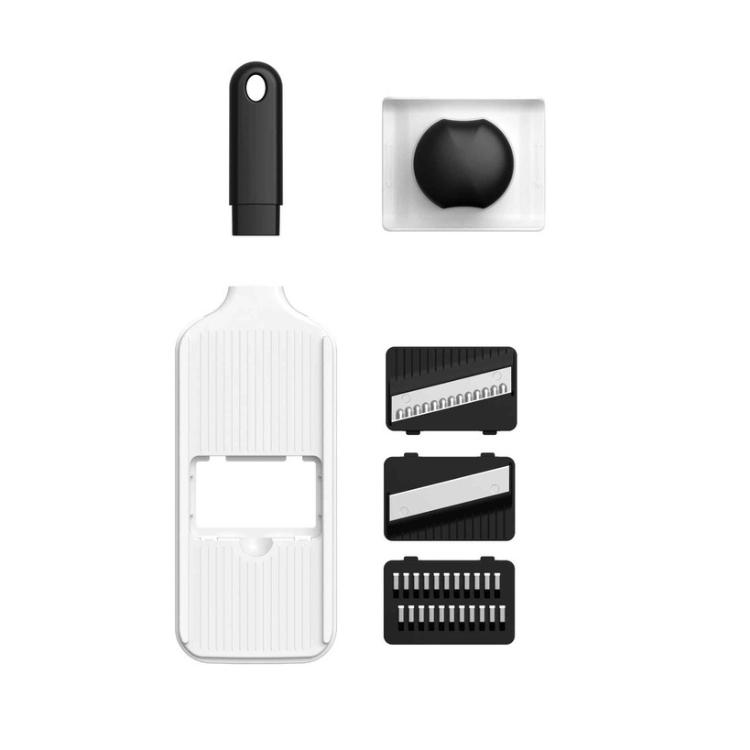 Deli ročnega rezalnika mandolina z različnimi rezili in zaščitnim držalom.