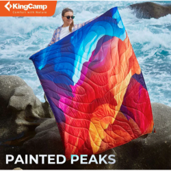 KingCamp večnamenska kamping odeja Painted Peaks z barvitim vzorcem, uporabljena na skalah ob morju.