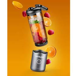 Nutribullet prenosni blender v razstavljenem prikazu z lebdečimi sestavinami (pomaranča, maline, led)