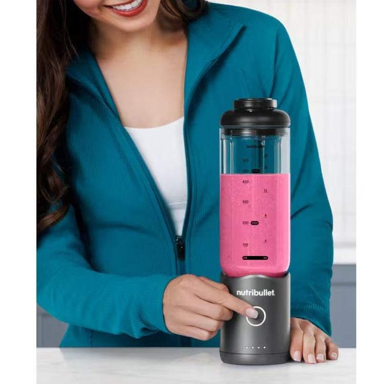 Nutribullet prenosni blender v uporabi, priprava smoothija z gumbom za vklop in napolnjeno posodo