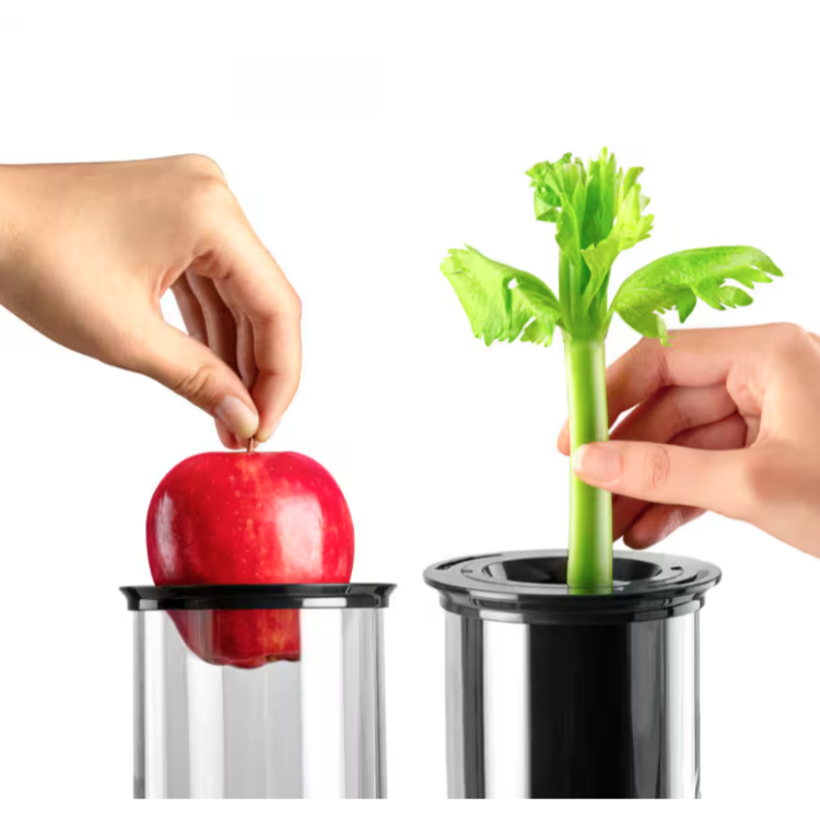 Prikaz vstavljanja jabolka in stebla zelene v odprtino za dovod sestavin pri Nutribullet sokovniku