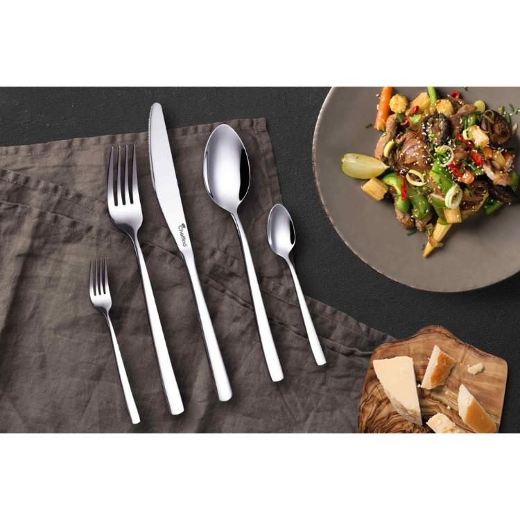 Cheffino Aria jedilni pribor pogrnjen na mizi ob postreženi hrani in siru.