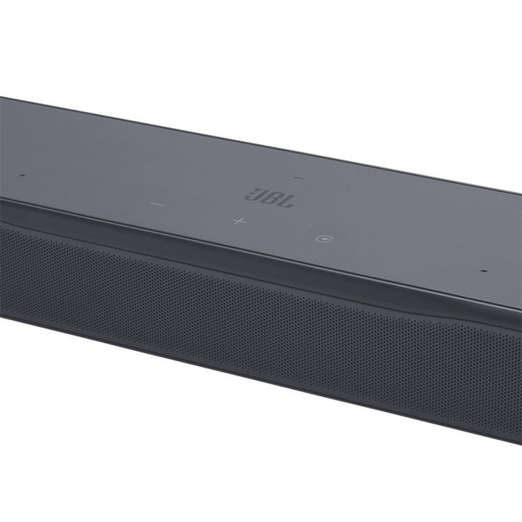 Soundbar JBL 500 M2 detajl zgornje plošče z upravljalnimi tipkami in kovinsko mrežico zvočnika.