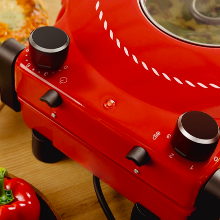 Cecotec Fun Pizza&Co. aparat za peko pice v rdeči barvi, prikazan z nastavitvenima gumboma za temperaturo in čas peke.