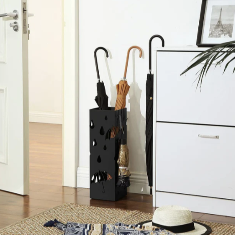 Črno kovinsko stojalo za dežnike v predsobi, shranjevanje več dežnikov.
