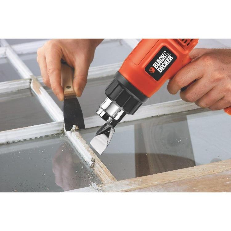 Fen za vroč zrak Black+Decker v uporabi pri odstranjevanju barve s površine, natančno segrevanje materiala.