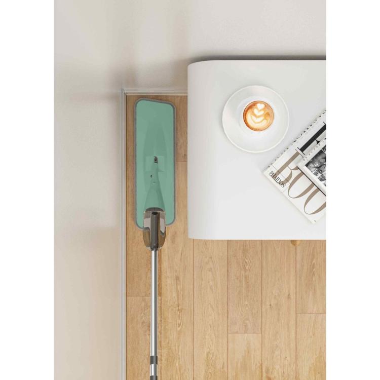 Čistilec tal spray mop shranjen ob steni v sodobnem bivalnem prostoru.