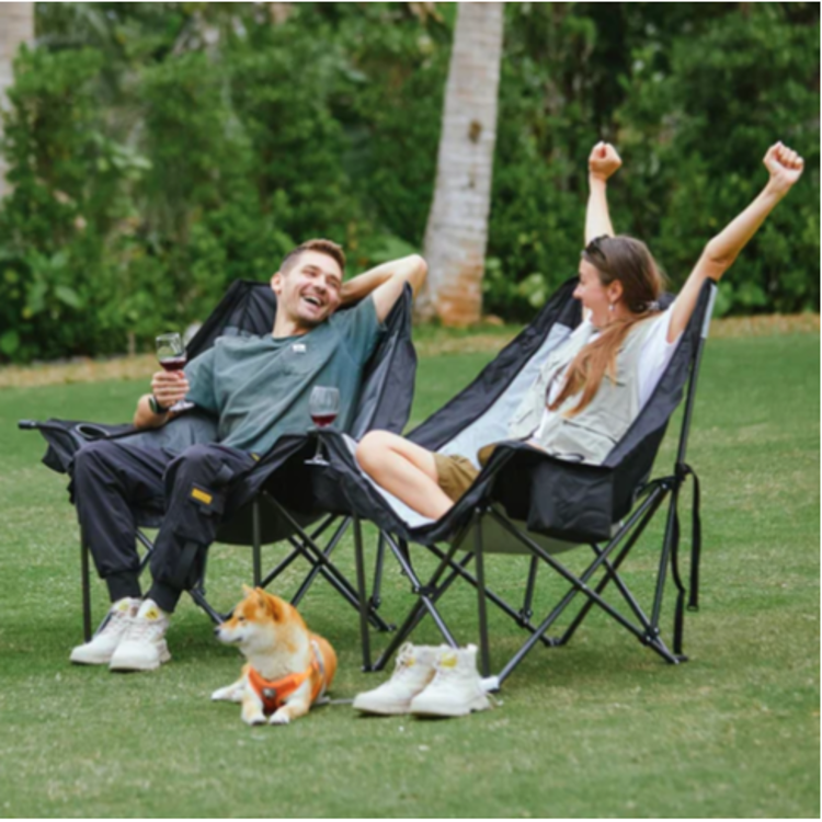 Dva zložljiva kamping stola KingCamp na travi, primer sproščene uporabe na prostem.