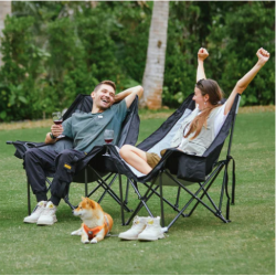 Dva zložljiva kamping stola KingCamp na travi, primer sproščene uporabe na prostem.