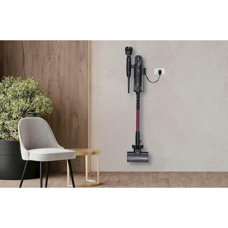 Baterijski sesalnik Hoover nameščen na stenski nosilec za shranjevanje in polnjenje.