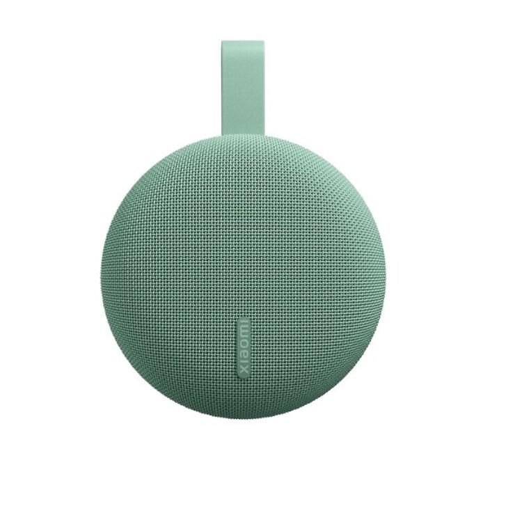 Xiaomi zelen okrogel prenosni zvočnik z mrežasto teksturo, ujemajočim trakom in logotipom Xiaomi na sprednji strani.