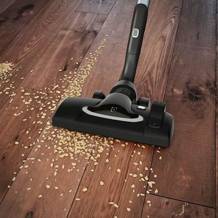 Talna krtača sesalnika Electrolux UltraOne med sesanjem lesenih tal z drobtinami.