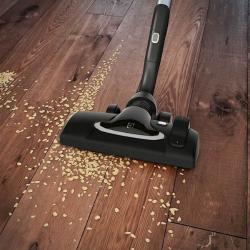 Talna krtača sesalnika Electrolux UltraOne med sesanjem lesenih tal z drobtinami.
