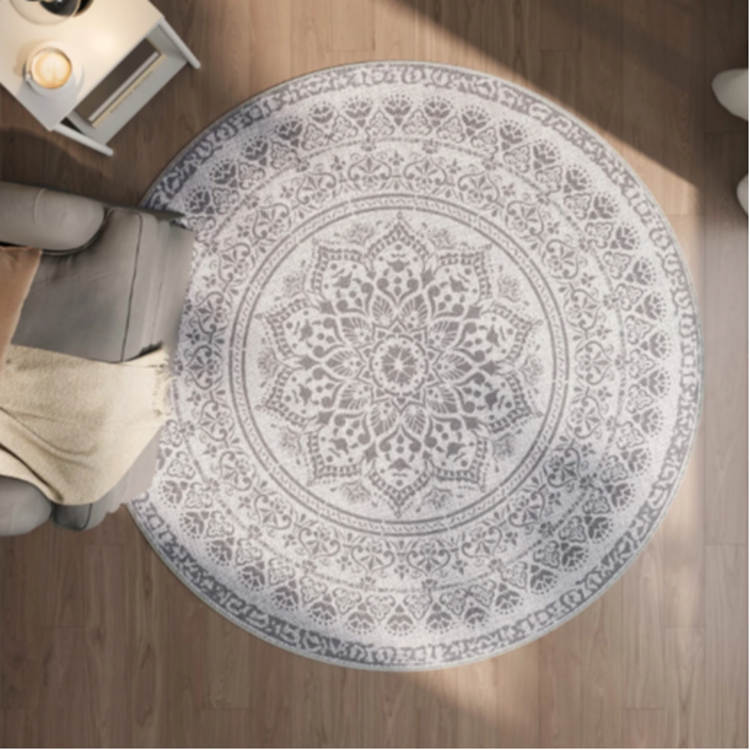 Songmics okrogla preproga z dekorativnim vzorcem v dnevnem prostoru na lesenih tleh.