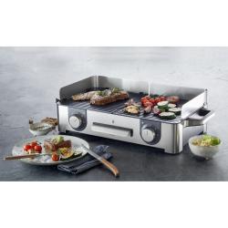 WMF Lono Master Grill namizni žar z dvema conama, na katerem se pečejo meso (zrezek, piščanec) in zelenjava (paradižniki, bučke, čebula)