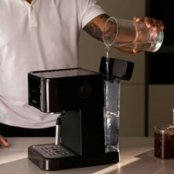 Cecotec espresso kavni aparat v črni barvi, prikazan med polnjenjem snemljivega rezervoarja za vodo.