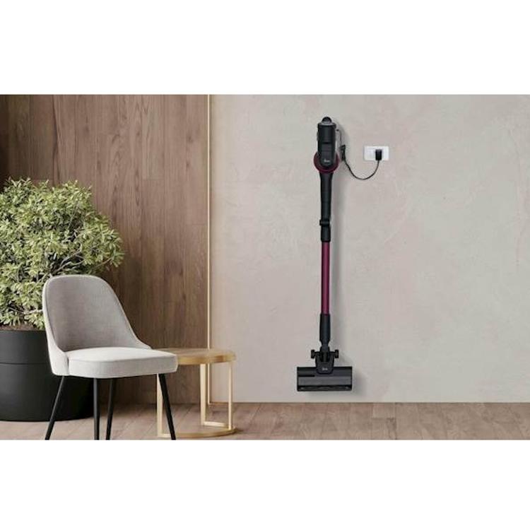 Baterijski sesalnik Hoover nameščen na stenski nosilec za shranjevanje in polnjenje.