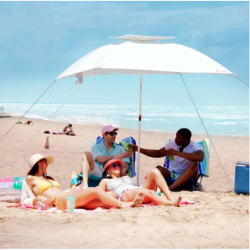 Plažni senčnik s senčnim nadstreškom, skupina ljudi sedi na brisačah na plaži pod zaščito pred soncem.